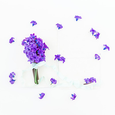 一束蓝色的风信子花，花瓣，纸卡和胶带在白色的背景。平躺，俯视图。图片下载