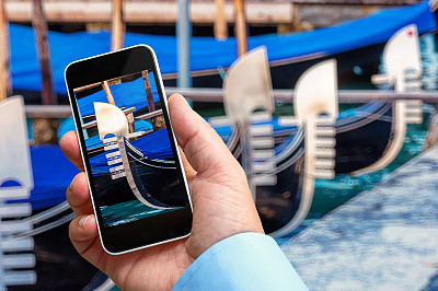 一名手持智能手机的男子正在拍摄一艘平底船的特写照片图片下载