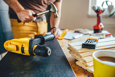 背景中有电钻和人用锤子素材图片