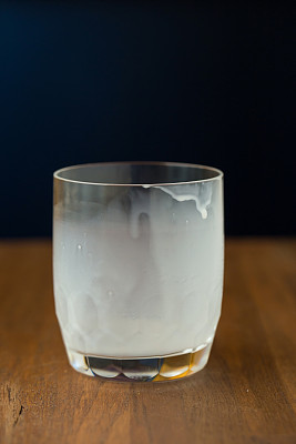 喝完后将热牛奶杯倒在木桌上图片下载