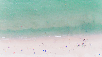 人们在阳光下沐浴，在沙滩上游泳和玩游戏。泰国南部的巴东海滩，滤镜图像图片下载