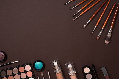 各种化妆品和画笔在棕色的背景图片下载
