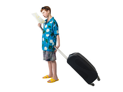 一个穿着衬衫和短裤的小男孩站在一个大箱子旁边，若有所思地看着白色背景上的地图图片下载