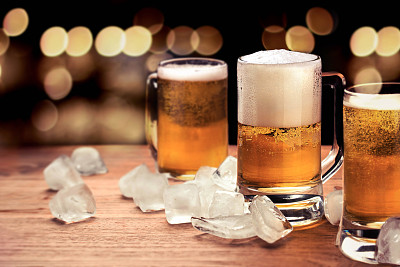 马克杯啤酒许多深色的玻璃灯夜景在酒吧背景。图片下载