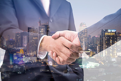 握手和城市之夜的双重曝光图片下载