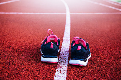 穿着人造光运动鞋的女人在跑道上奔跑图片下载