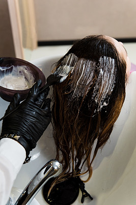 美与人的概念-发型师用染发剂和刷子在沙龙染发图片下载