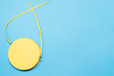 圆形的黄色钱包在一个彩色的蓝色背景图片下载