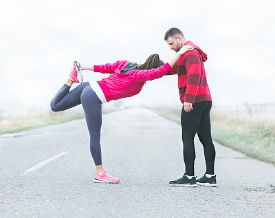 年轻的健身夫妇在跑步前伸展肌肉。图片下载