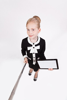 一个迷人的女学生在一个白色的背景，手里拿着写字板，用一根棍子为自己拍照，第一个人的照片图片下载