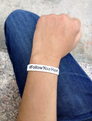 手腕上戴着白色腕带，手上穿着蓝色牛仔裤。图片下载