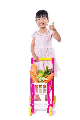 亚洲华人小女孩，购物车里装满了蔬菜图片下载