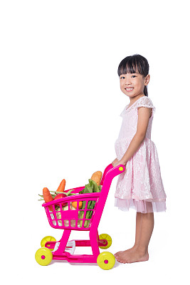 亚洲华人小女孩，购物车里装满了蔬菜图片下载
