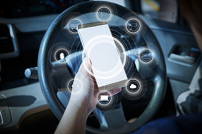 女性拿着智能手机进行网上购物和银行支付。车内暗无天日的背景。图片下载