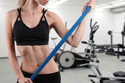 爱运动的年轻女子在健身房做伸展运动时使用橡皮筋图片下载