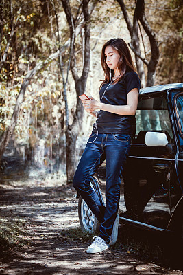 快乐的亚洲青年青少年使用和听音乐的手机与复古汽车。图片下载