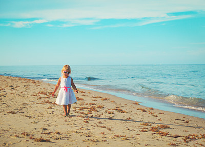 快乐可爱的小女孩走在沙滩上图片下载