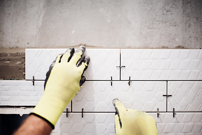 专业产业工人在浴室装修工程中安装小瓷砖图片下载