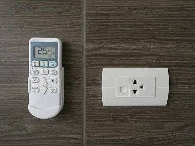 远程空气控制和电插头木墙纹理背景。图片下载