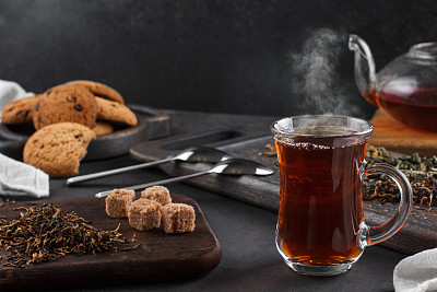 一杯热气腾腾的茶，黑暗背景下的静物图片下载