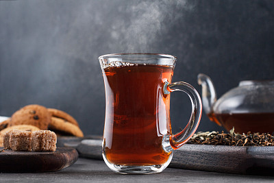 一杯热气腾腾的茶，黑暗背景下的静物图片下载
