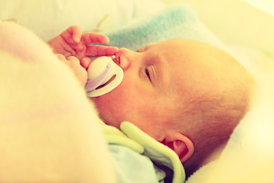 小新生儿叼着奶头睡觉的特写图片下载