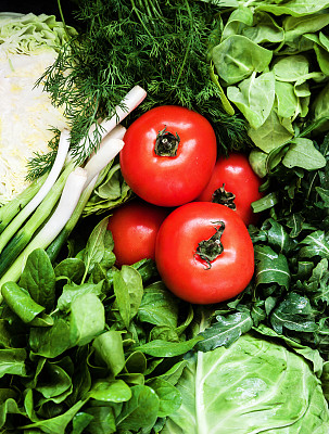 背景有很多新鲜的绿色不同的蔬菜，香草和红色的西红柿，俯视图，特写。健康的概念，适当的营养，饮食，排毒，净化图片下载