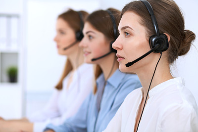 呼叫中心运营商。年轻漂亮的女商人戴着耳机。图片下载