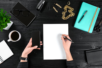 混合办公用品和小工具的木制书桌背景。从上面的观点图片下载