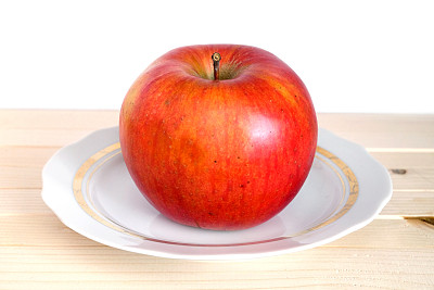 又大又熟的红苹果放在白色的盘子里，木制的架子上镶着金边图片下载