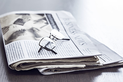 报纸放在木桌上素材图片