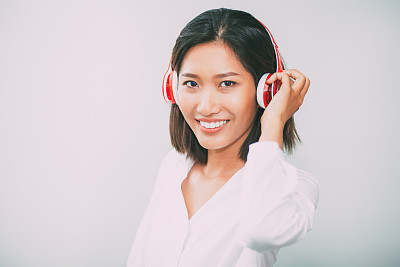 戴着耳机微笑的漂亮女人的特写图片下载