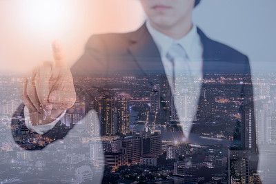 年轻的亚洲商人指向目标和夜景的双重曝光图片下载