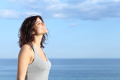 美丽的女孩在沙滩上呼吸和微笑图片下载