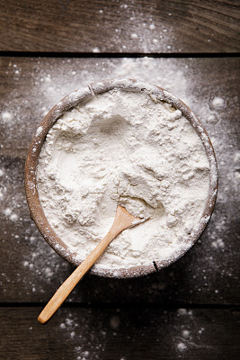 白木桌上放着一碗白面粉，俯视图图片下载