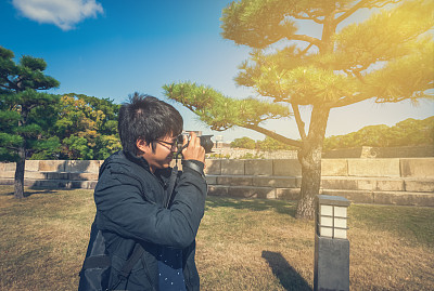 一名亚洲男子在日本花园拍照图片下载