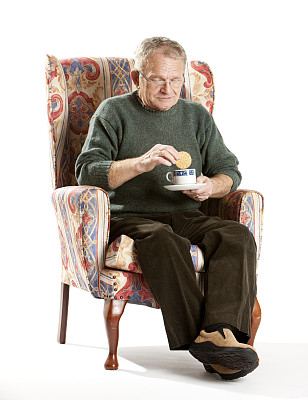 老年人:年长的男子在浸泡他的饼干服图片下载