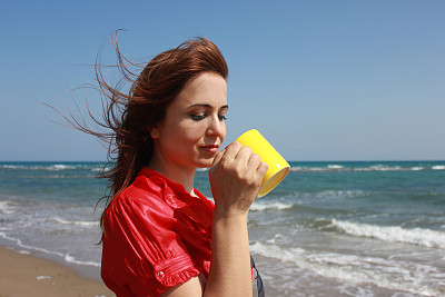 穿红色衬衫的喝水的女人图片下载