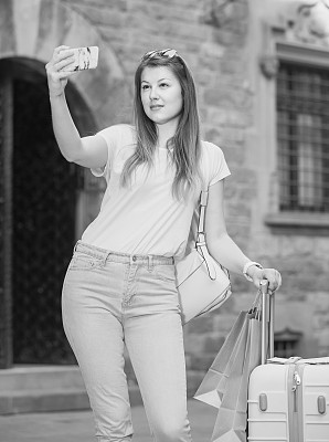 年轻的旅行者在城市里散步自拍图片下载