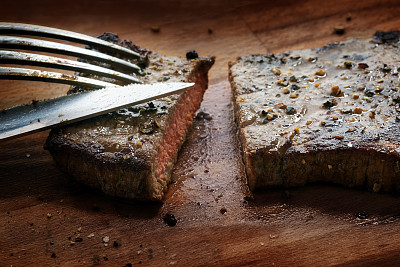 小牛排，中等油炸，刀叉切片在一个质朴的木板，近图片下载