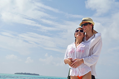 快乐的年轻夫妇在海滩上玩得开心图片下载