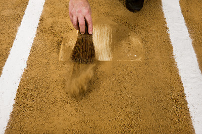 正在清理本垒板的棒球裁判。玩球图片下载