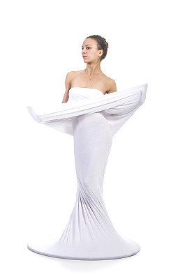 一个年轻的，微笑的女孩穿着白色概念性的裙子。图片下载