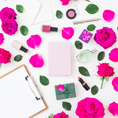 时尚书桌，化妆品-口红，眼影，指甲油，粉红玫瑰和剪贴板，笔记本，钢笔在白色的背景。平躺，俯视图。美丽或婚礼博客作文图片下载