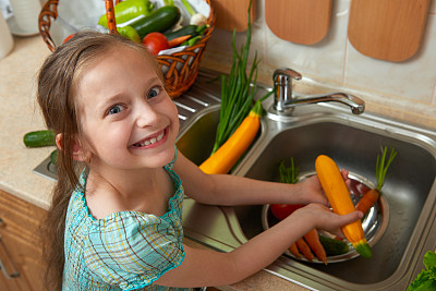 女童在厨房内清洗蔬菜和新鲜水果，倡导健康饮食理念图片下载