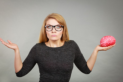 戴眼镜的女人拿着大脑不知所措图片下载