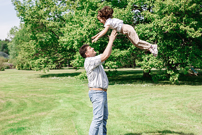 爸爸和他的女儿玩，把她扔上去接住。图片下载