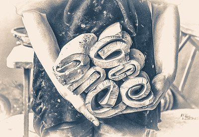 陶工女师傅拿着许多层切好的陶土图片下载