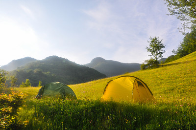 早晨在山脚下。在大自然的草地上搭两个帐篷。图片下载
