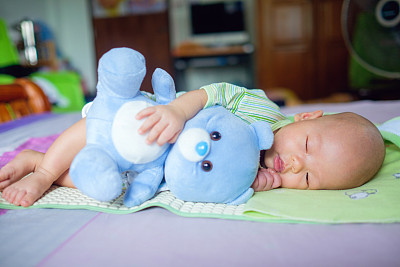 甜美的亚洲可爱的小亚洲2个月大的新生婴儿男孩的孩子睡觉与蓝色的泰迪熊玩具图片下载